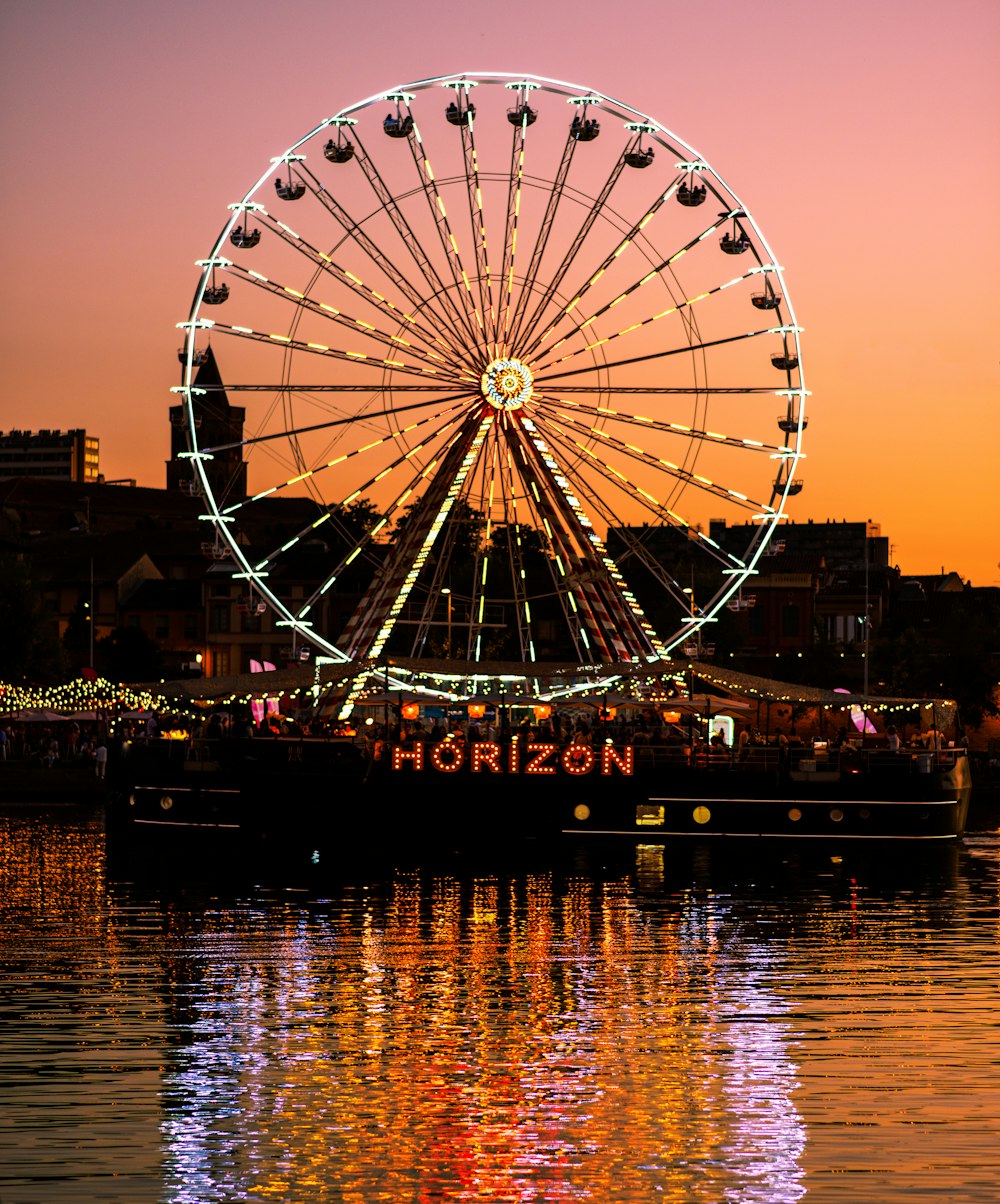 a ferris wheel sitting on top of a body of water