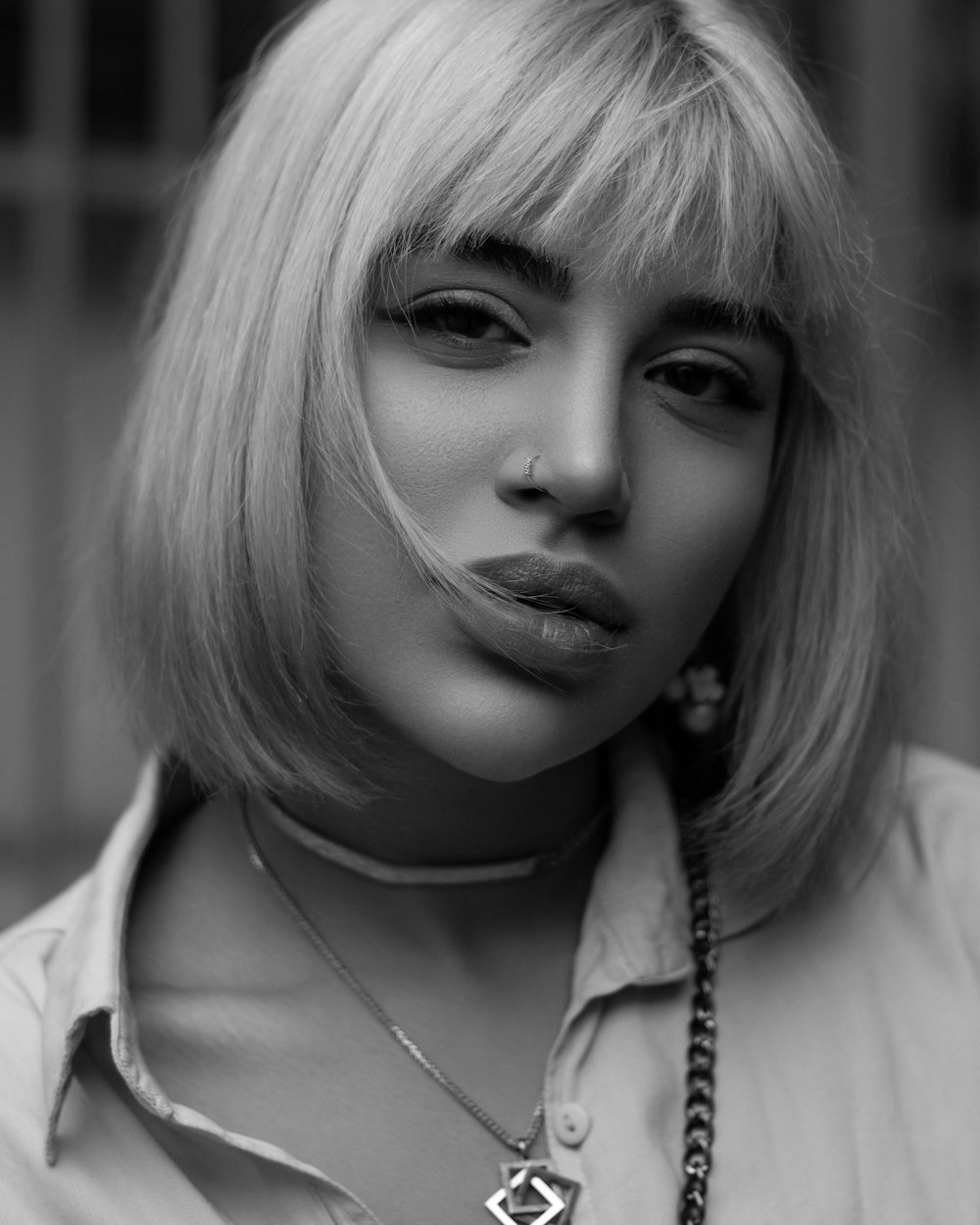 a black and white photo of a woman wearing a necklace