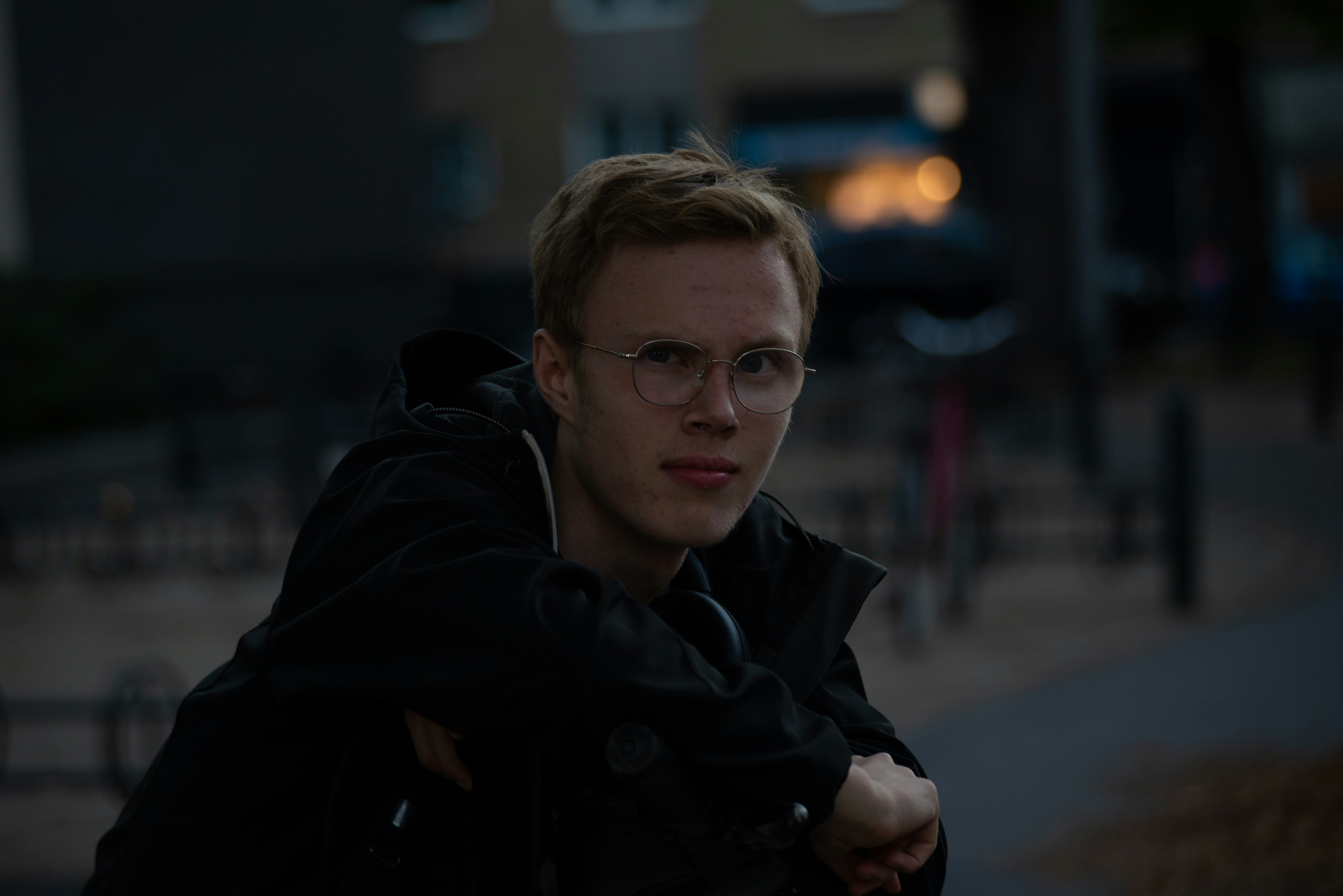 a man wearing glasses and a black jacket