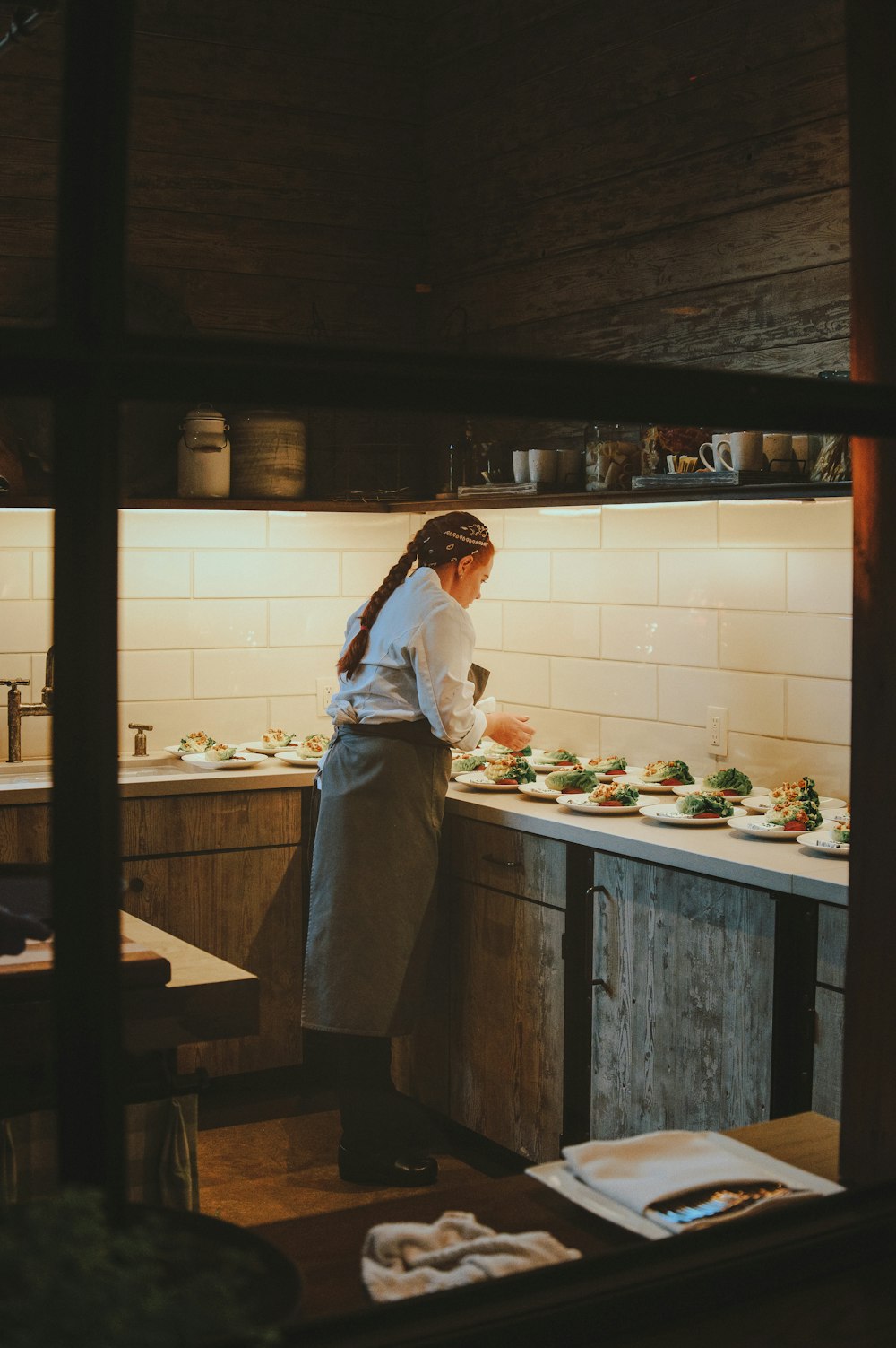 a woman standing in a kitchen preparing food