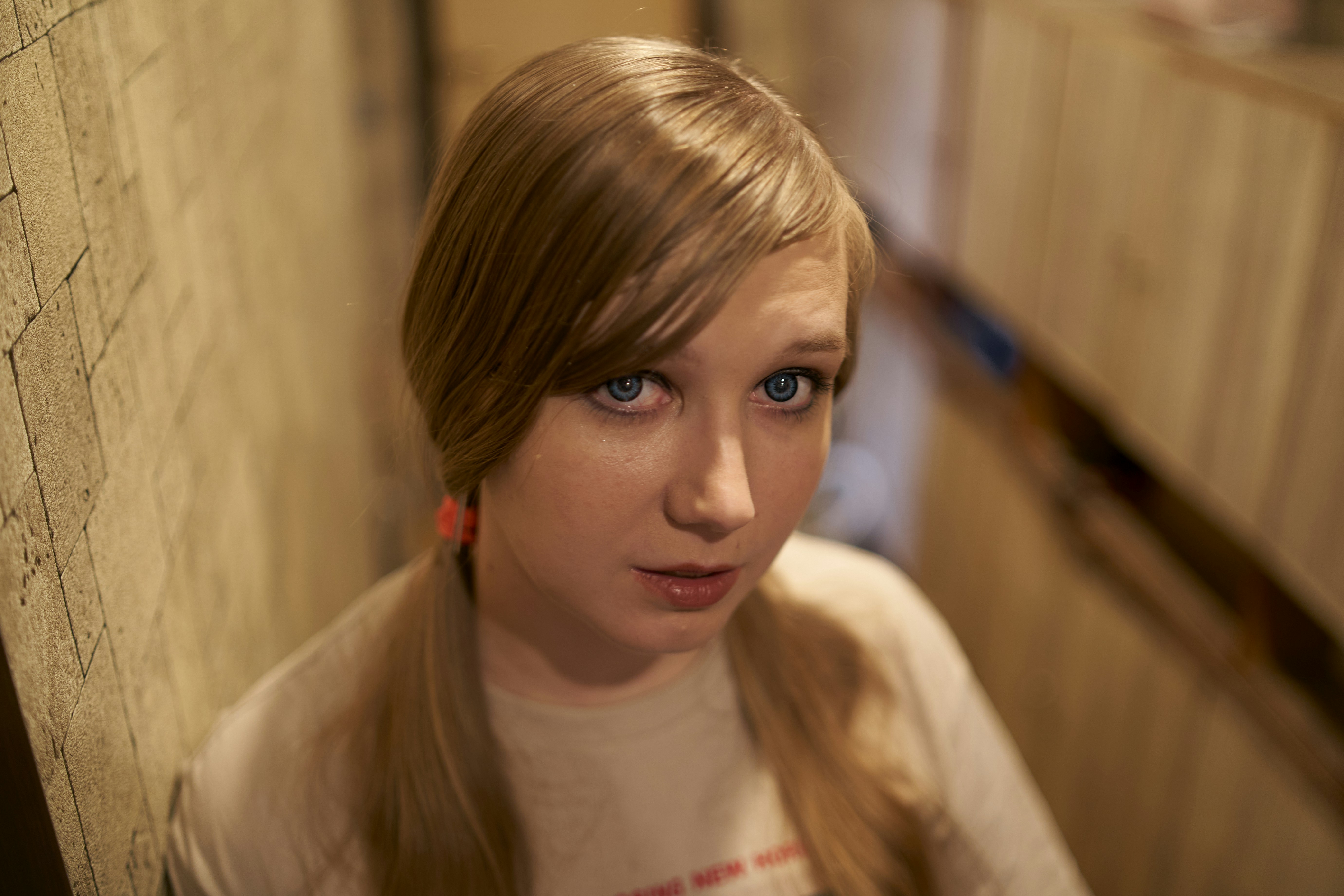 a girl with long hair standing in a hallway