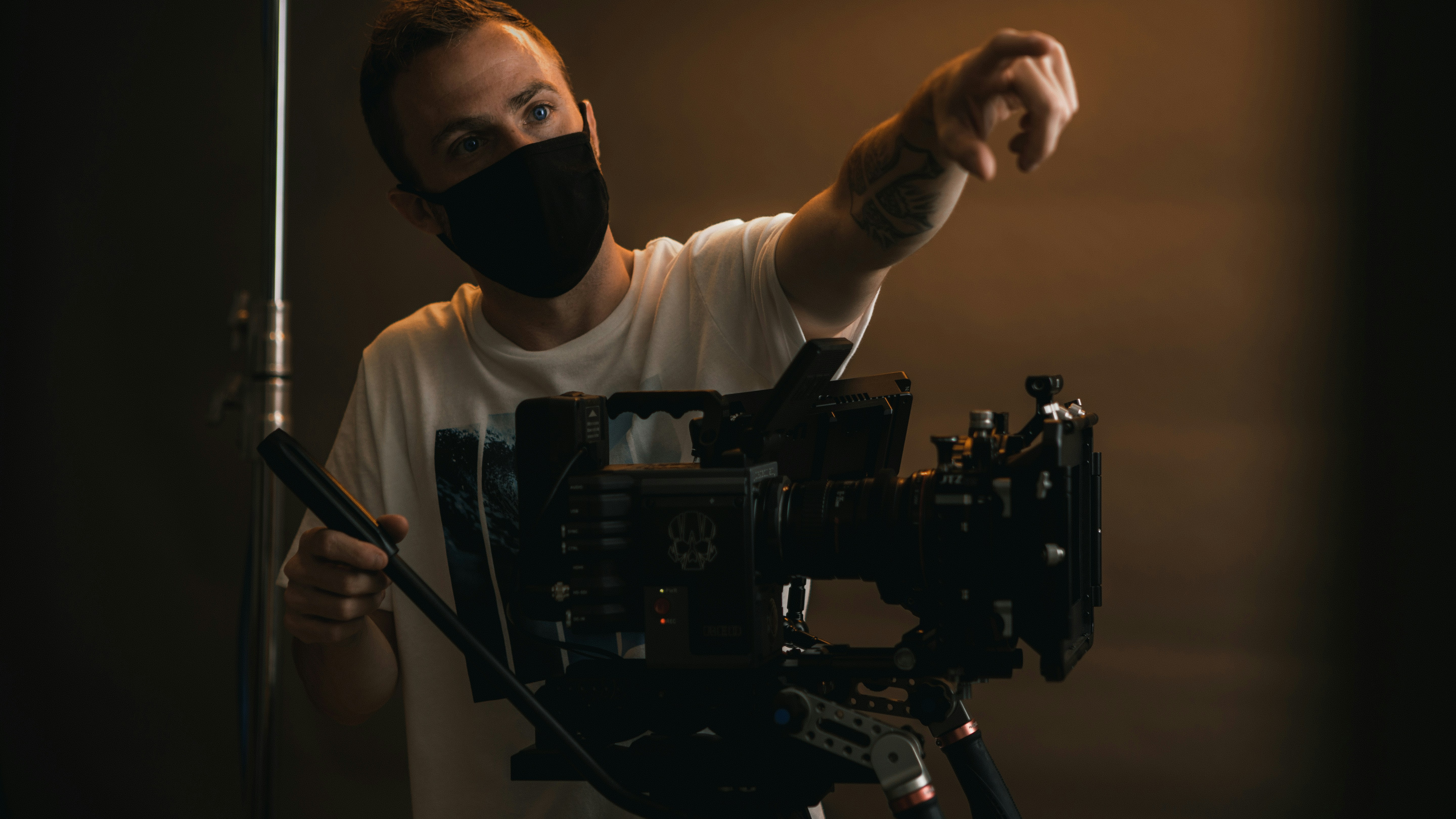 a man wearing a face mask and holding a camera