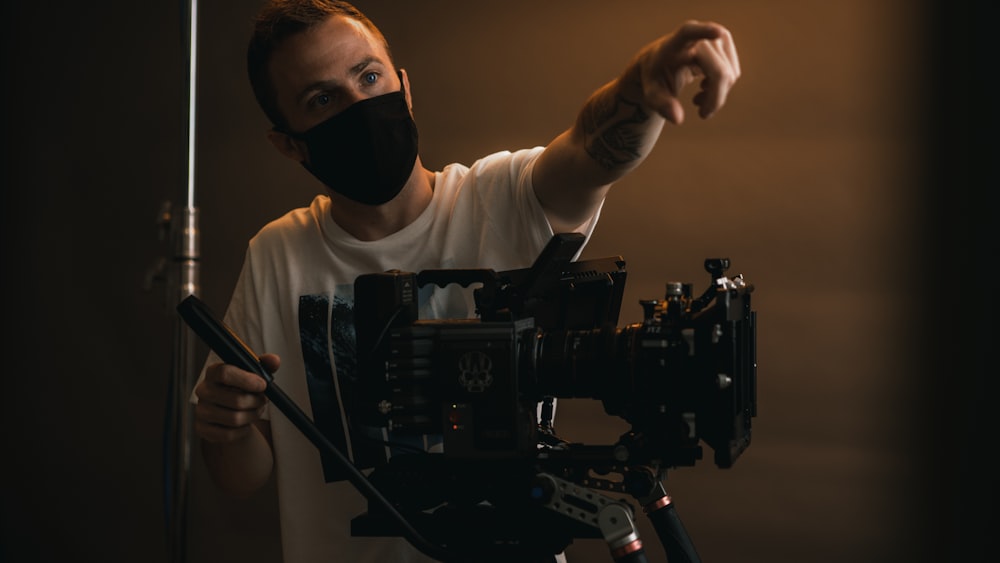 a man wearing a face mask and holding a camera