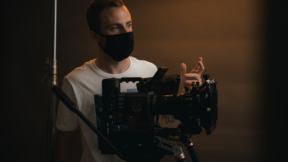 a man wearing a face mask while holding a camera