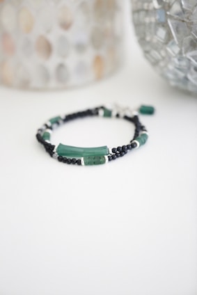 a beaded bracelet with green beads and black beads