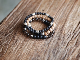 a couple of bracelets sitting on top of a wooden table