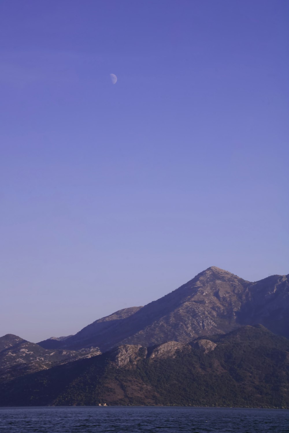 a mountain range with a moon in the sky