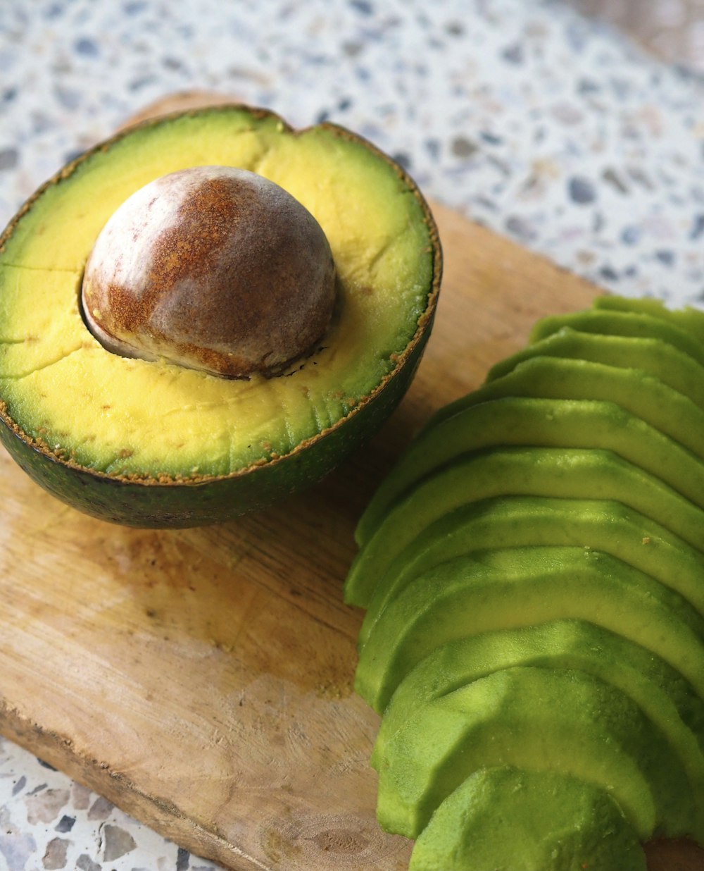an avocado cut in half on a cutting board