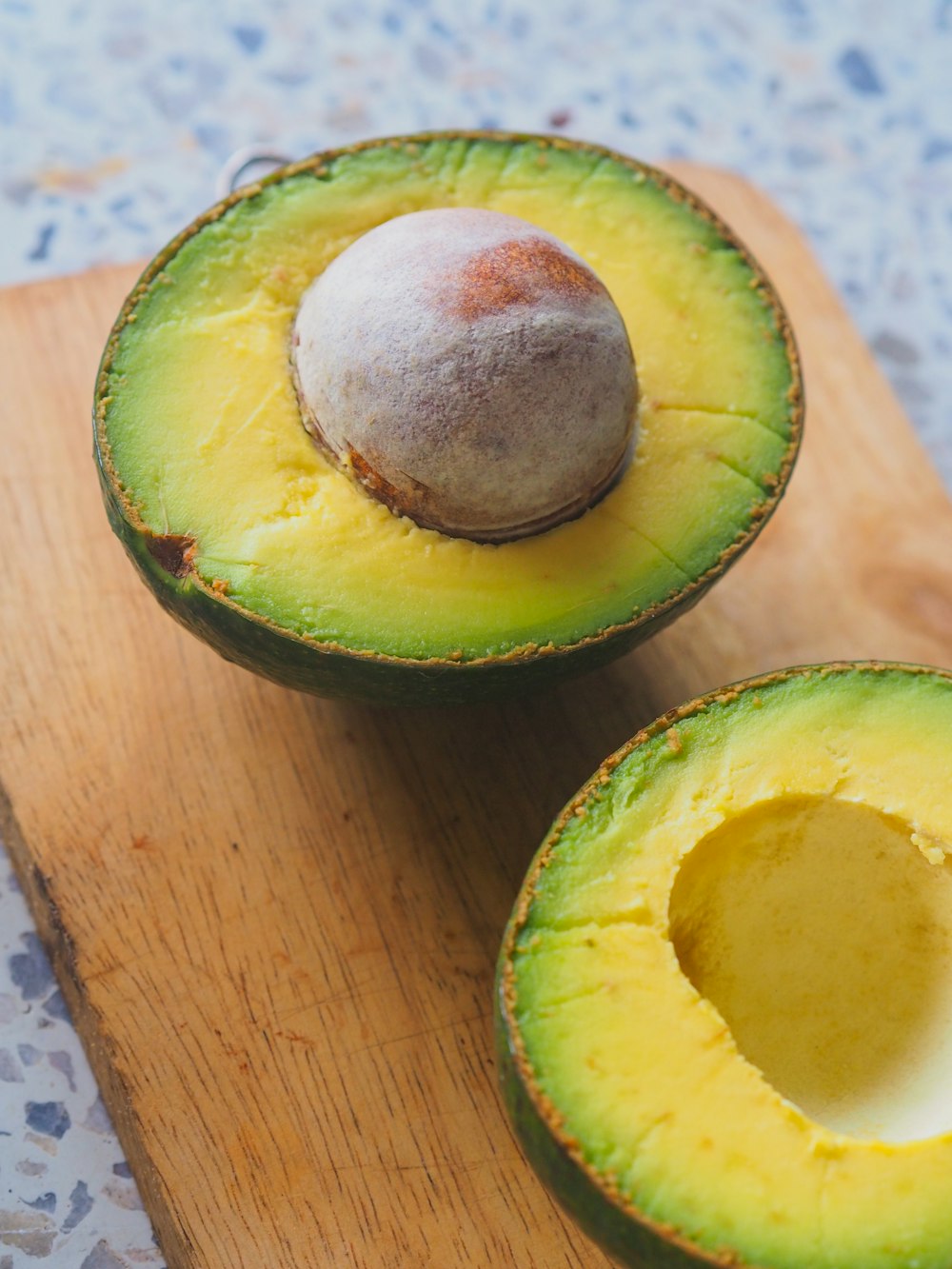 an avocado cut in half on a cutting board