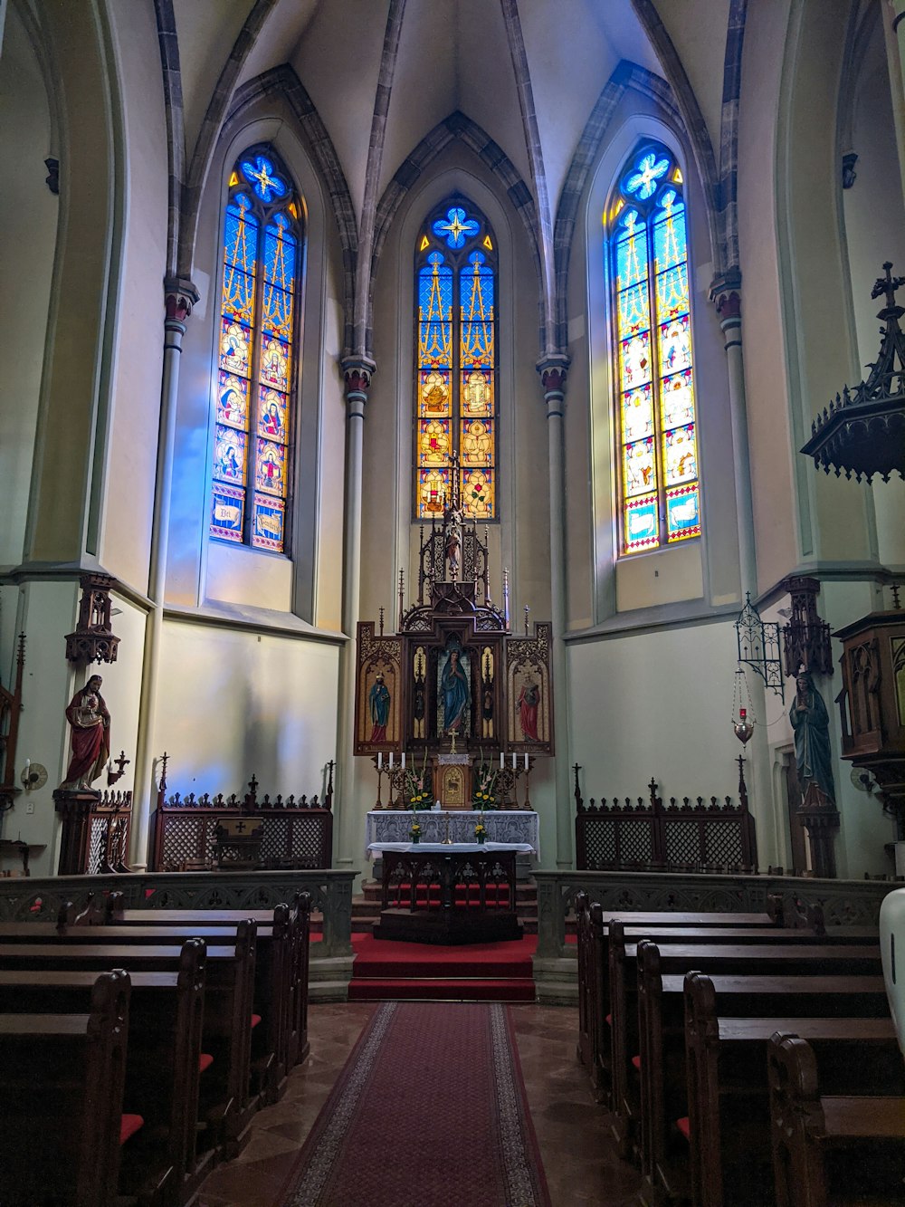 a church with stained glass windows and pews