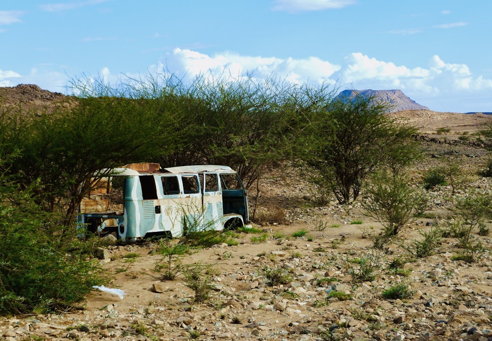 an old bus sitting in the middle of a desert