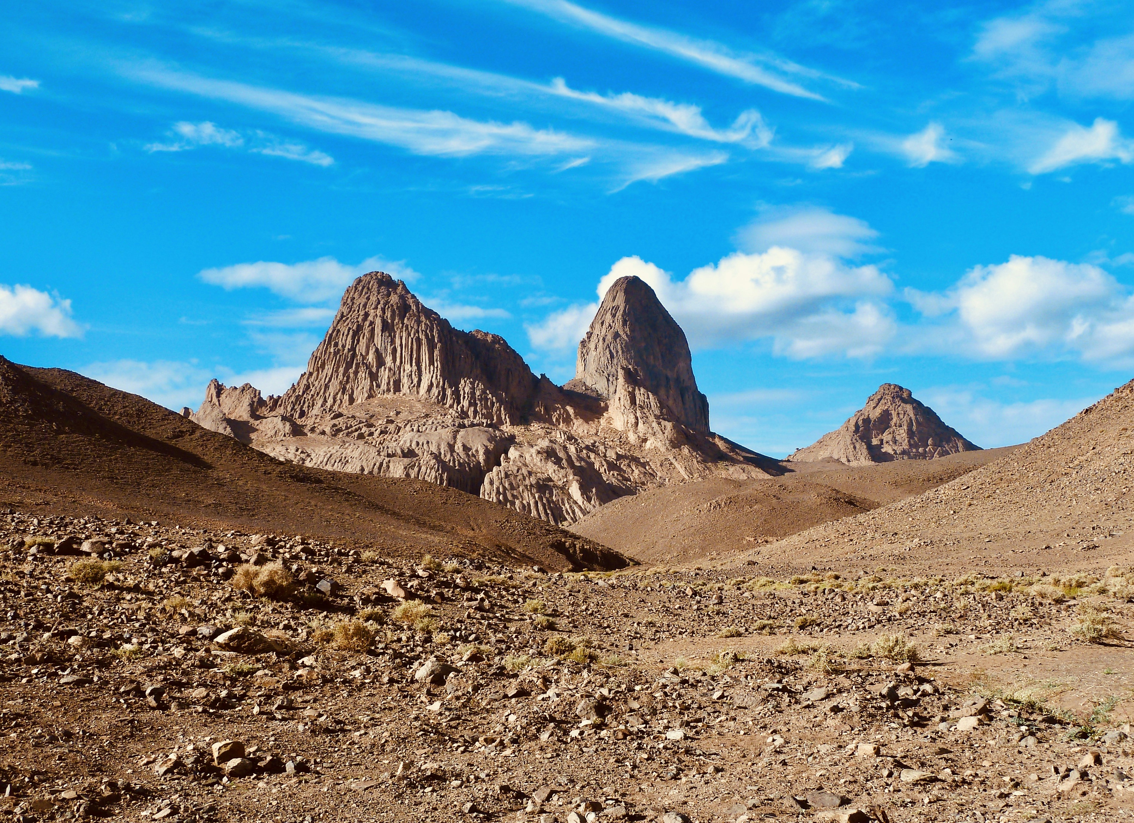 A mountain range in the desert under a blue sky