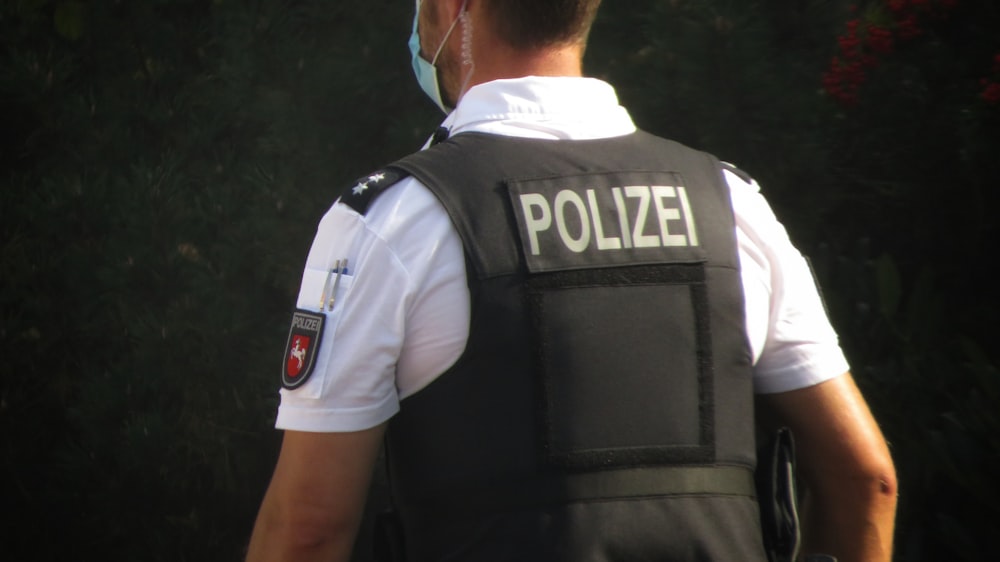 a police officer is standing in front of some trees