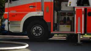Side view of a red fire truck in action with water spraying