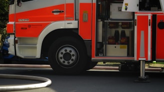 Side view of a red fire truck in action with water spraying