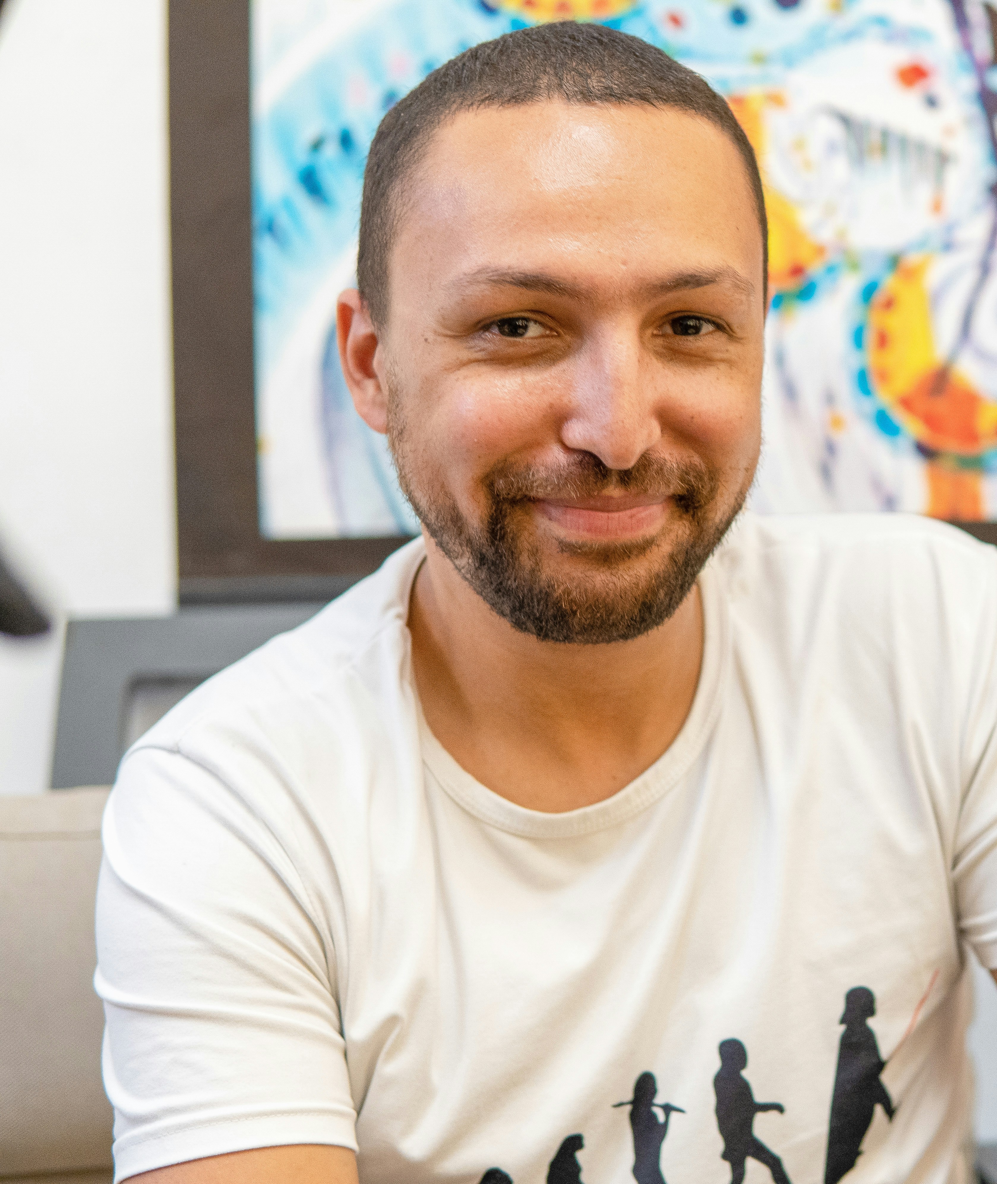 a man sitting in front of a table with a pizza on it