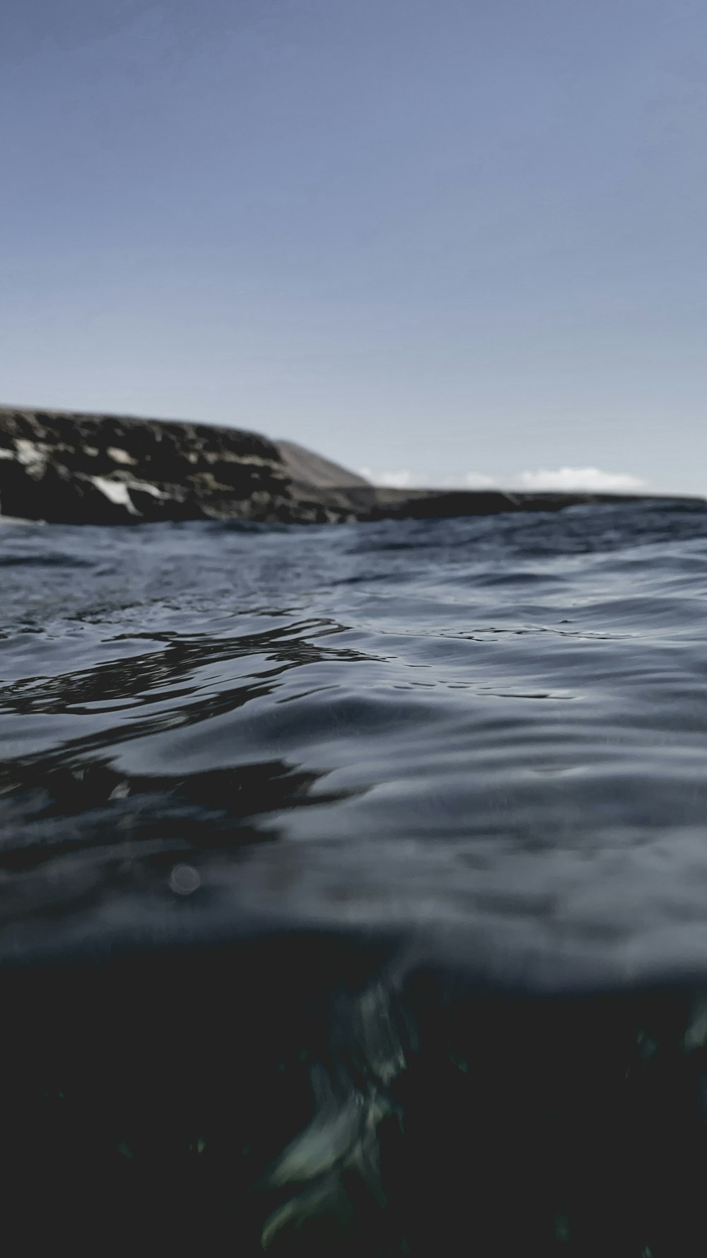 Un gran cuerpo de agua con una colina en el fondo