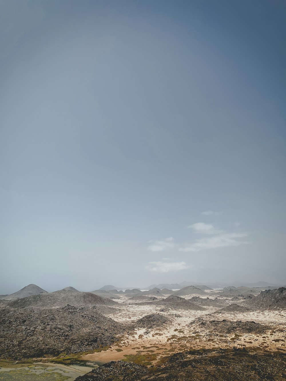 a view of a mountain range from the top of a hill