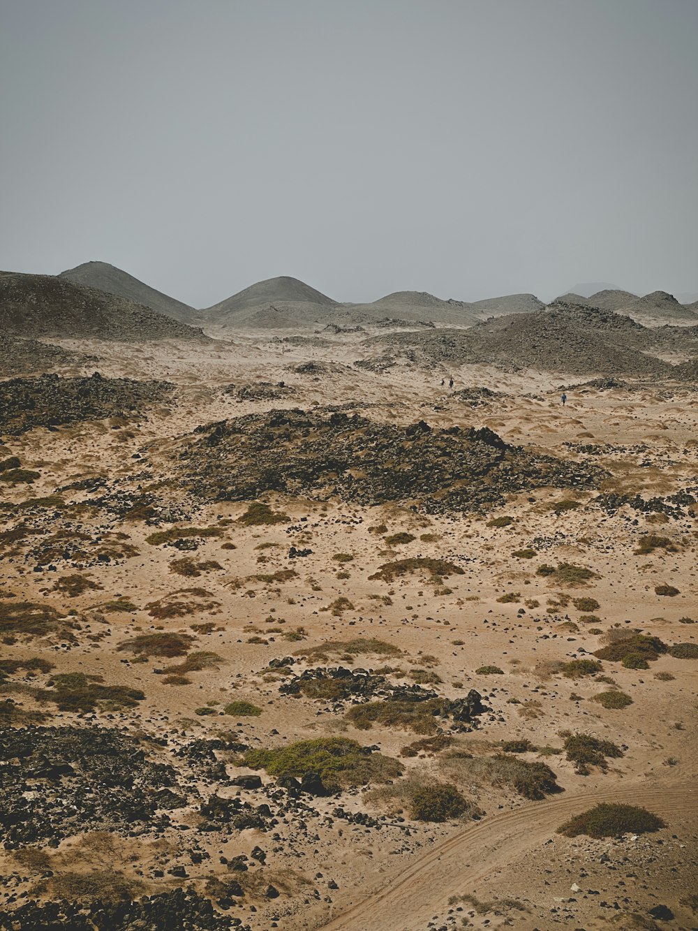 a dirt field with hills in the distance