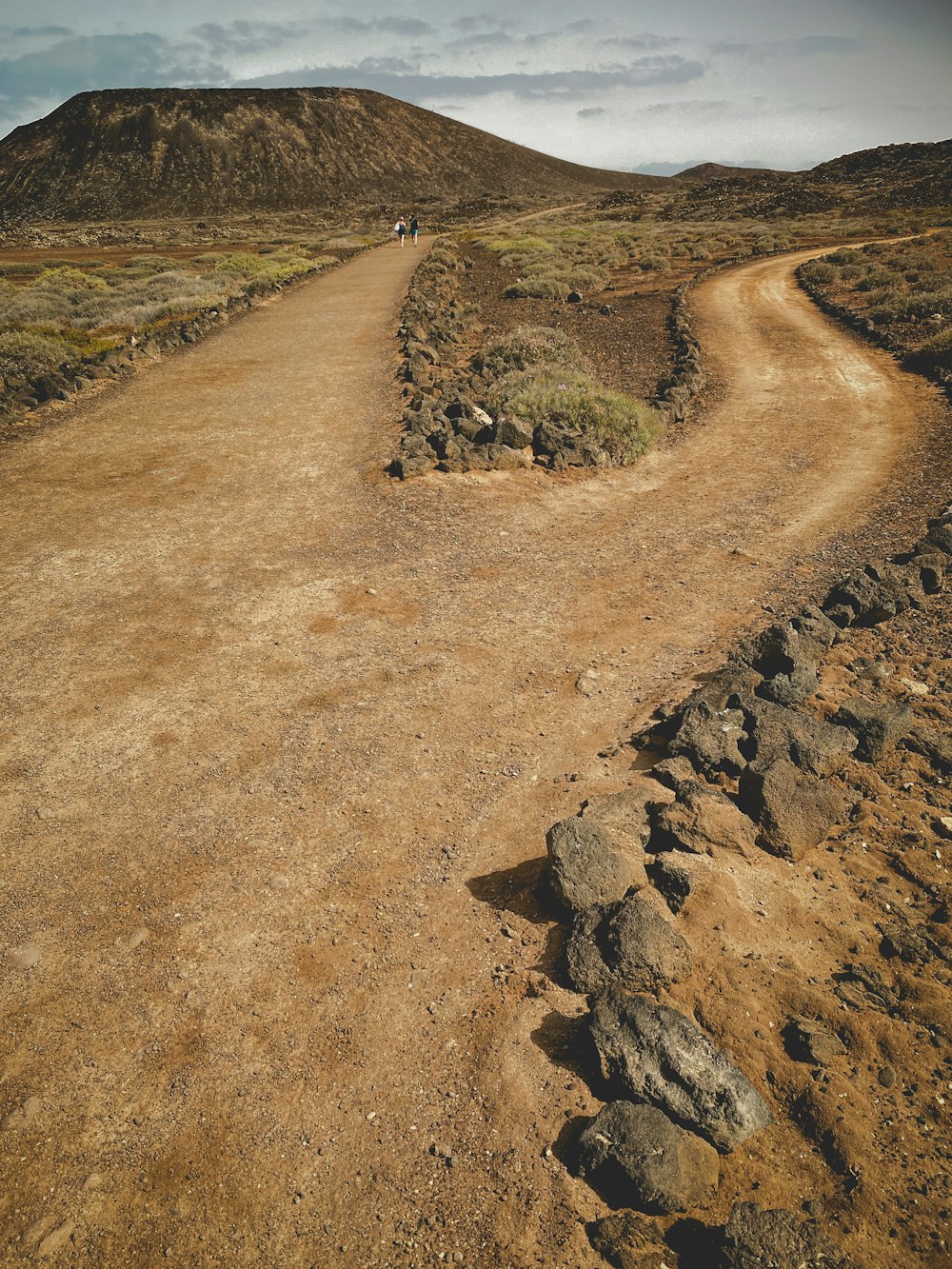 a person riding a bike down a dirt road