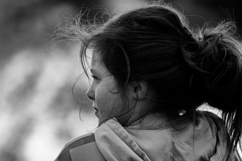 a woman with a ponytail is looking away from the camera