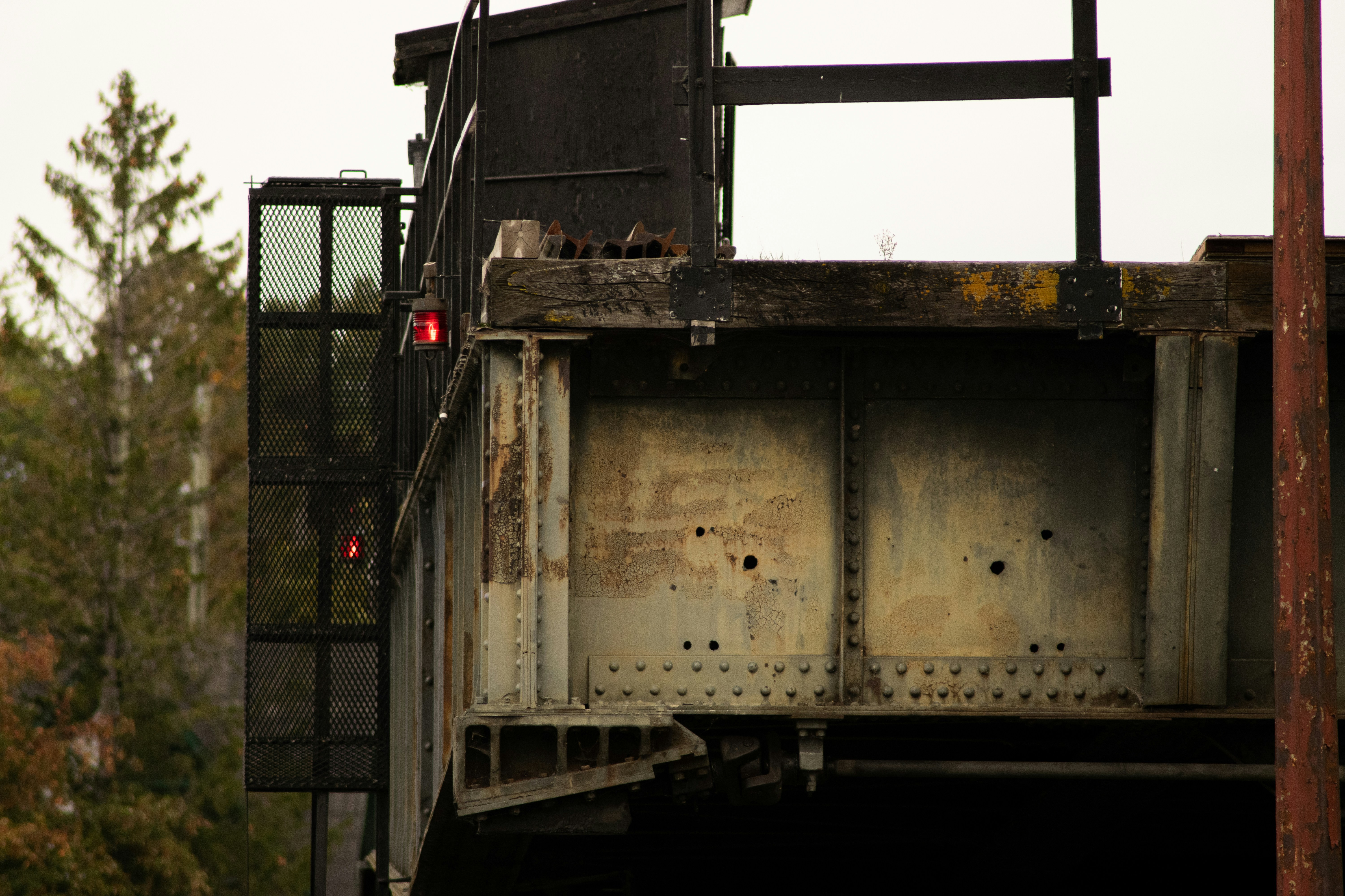 a rusted metal structure with a red light at the top