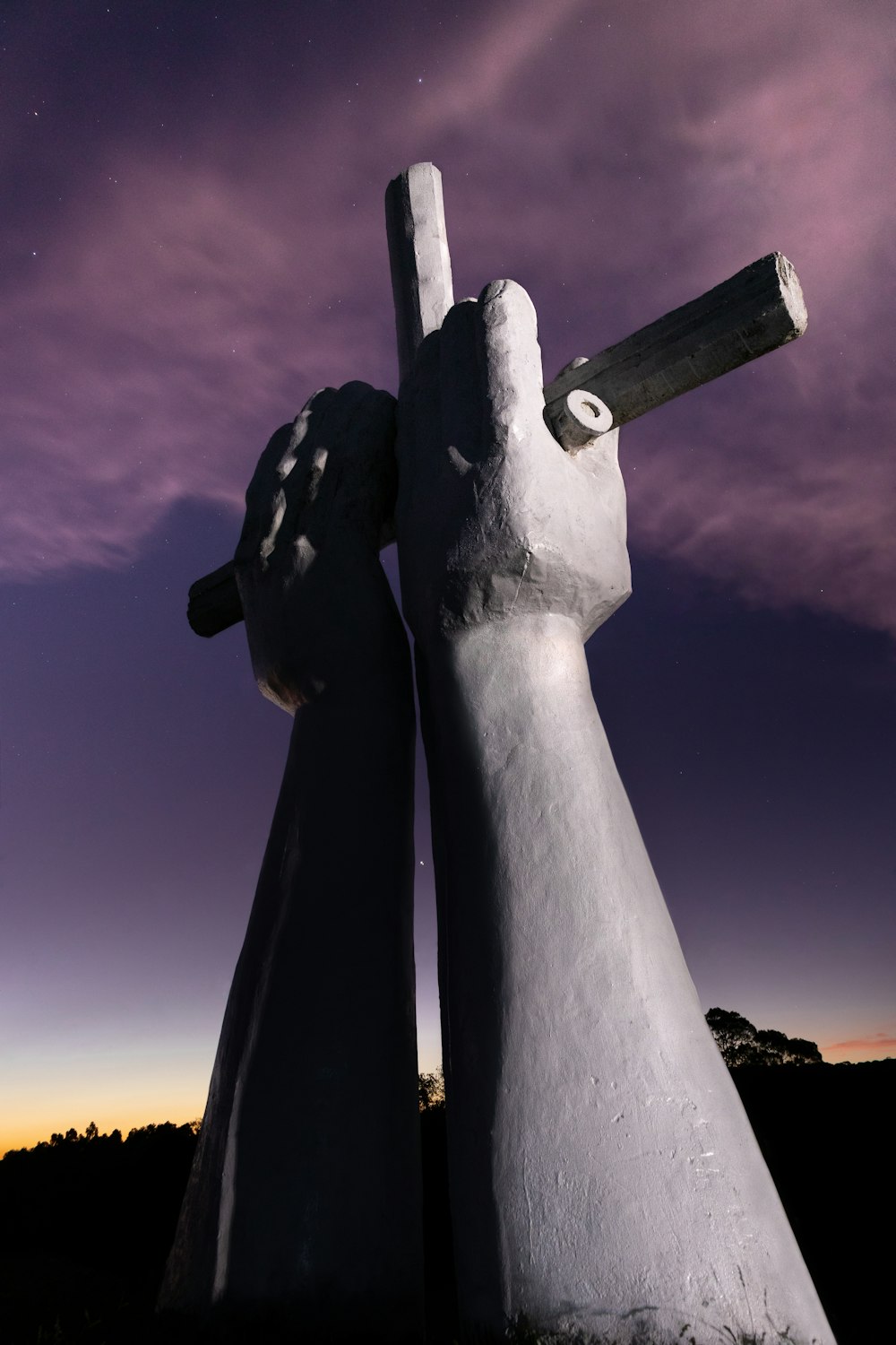 a couple of white statues with a sky in the background