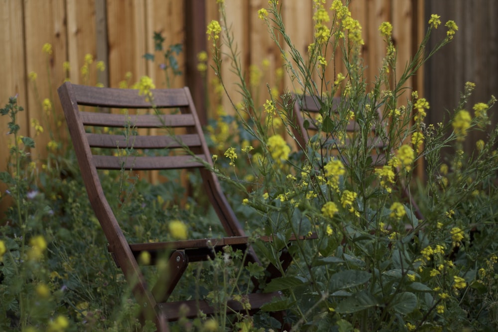 a wooden chair sitting in the middle of a garden