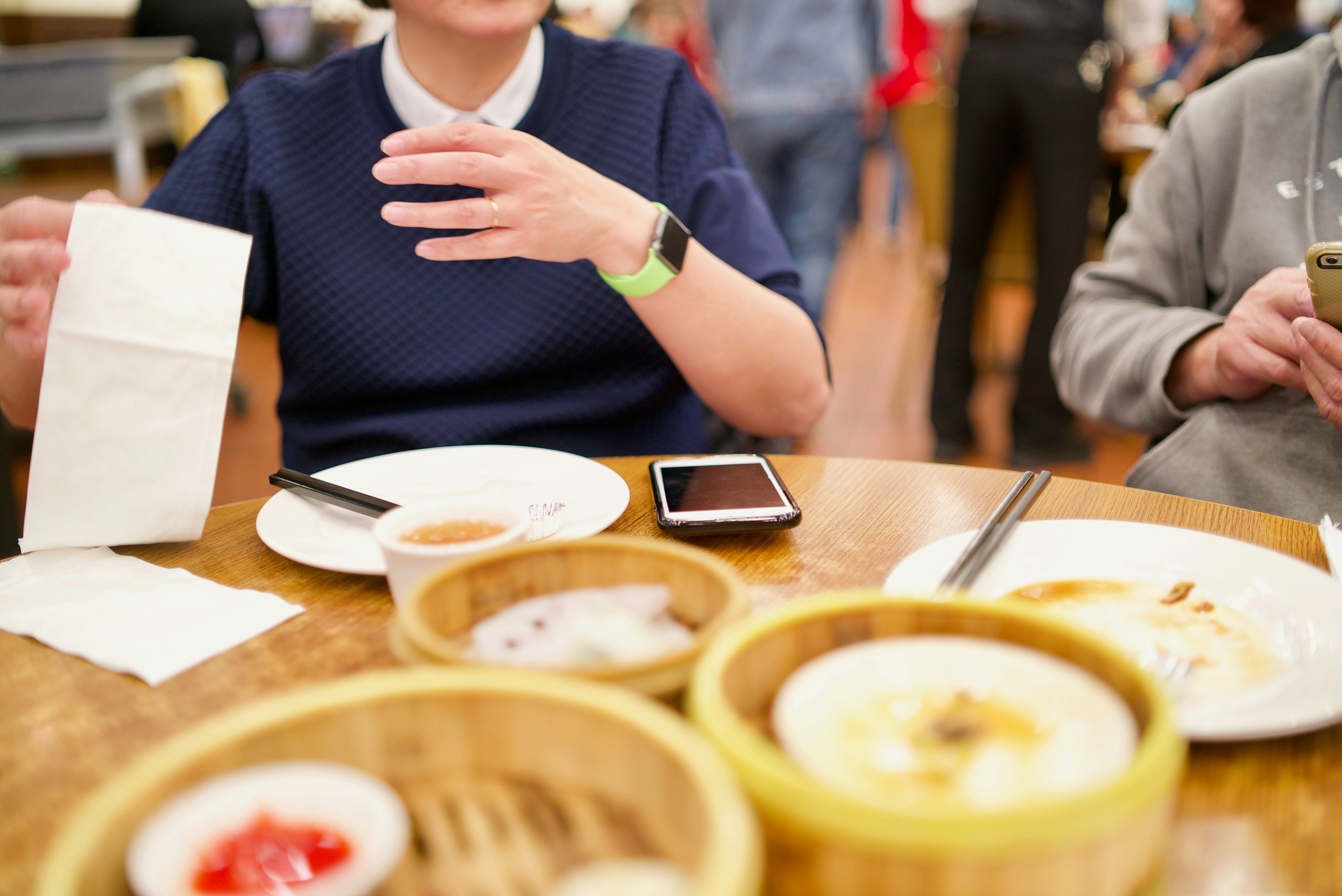 a group of people sitting around a wooden table, 