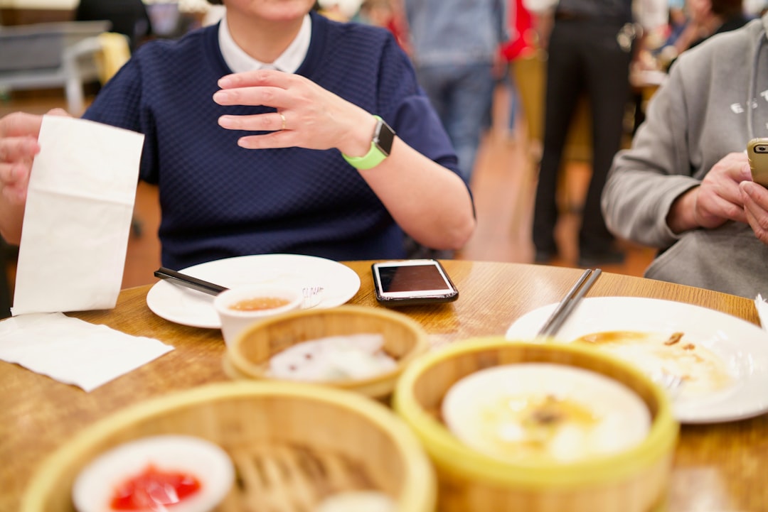 a group of people sitting around a wooden table,