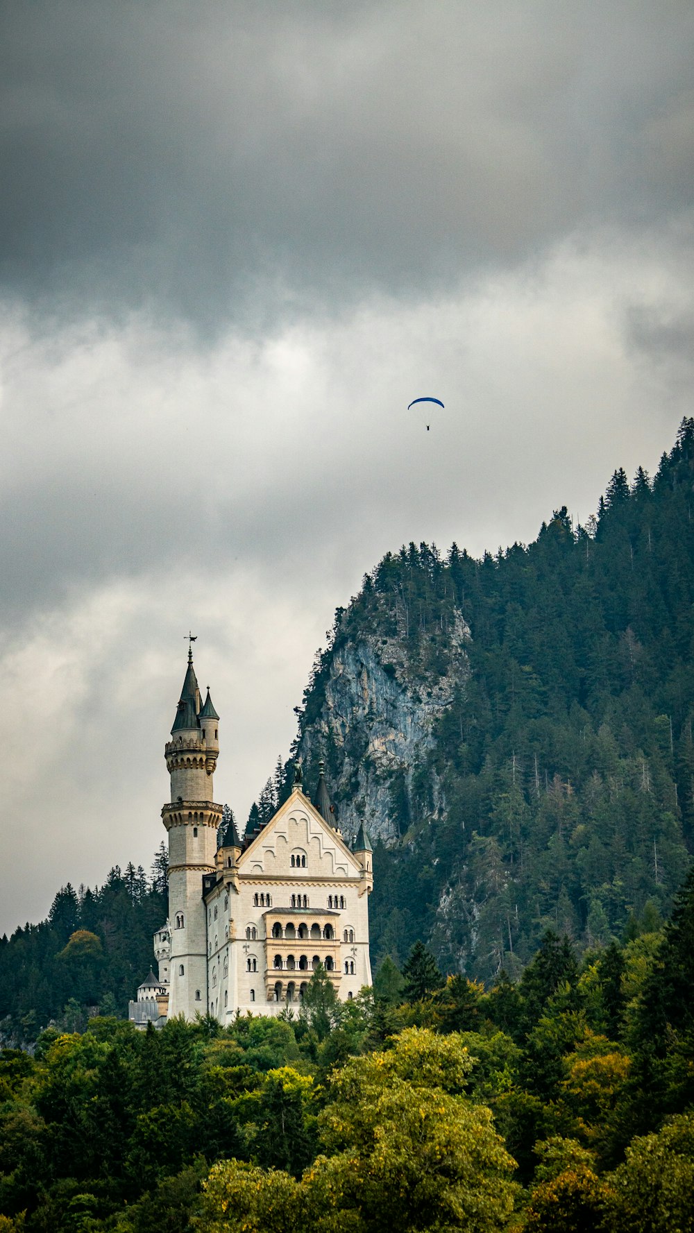 a large white castle sitting on top of a lush green hillside