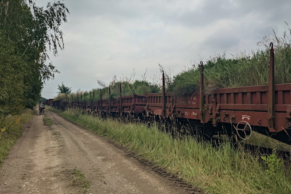 Un camino de tierra junto a un campo con un tren en él