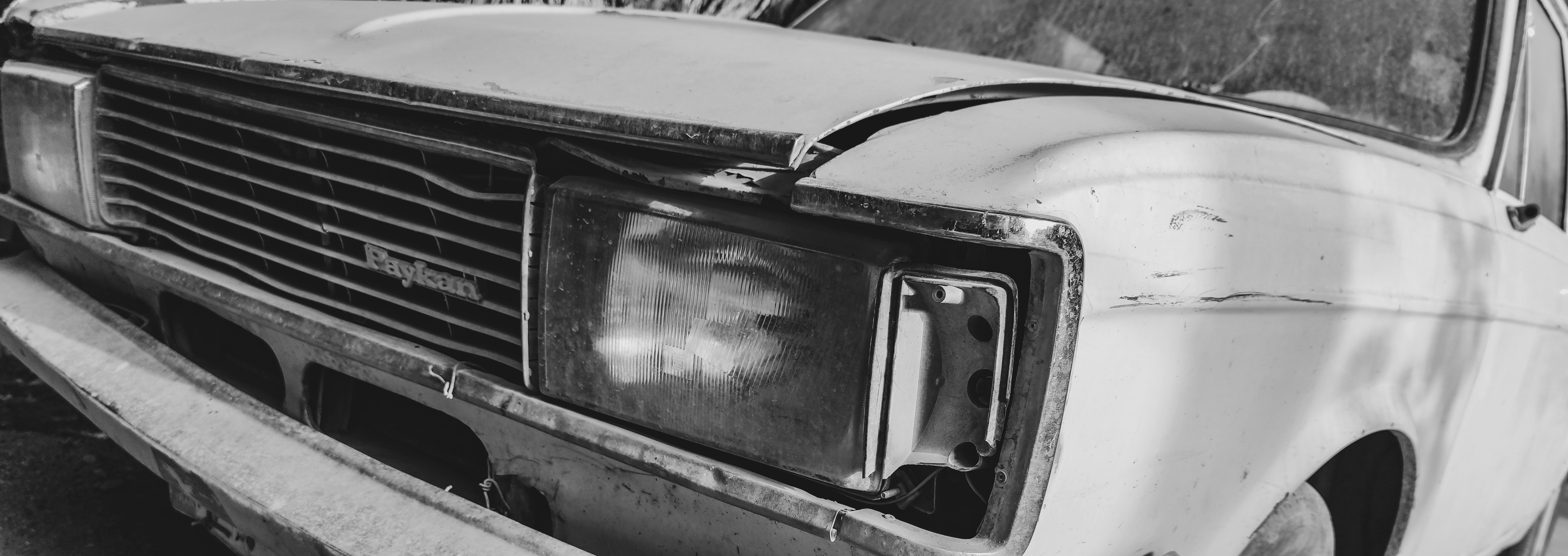 Ein altes Auto ist am Straßenrand geparkt