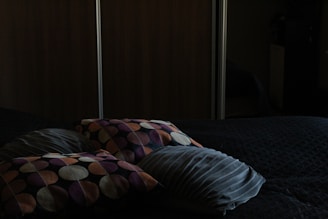 a bed with a black comforter and two pillows