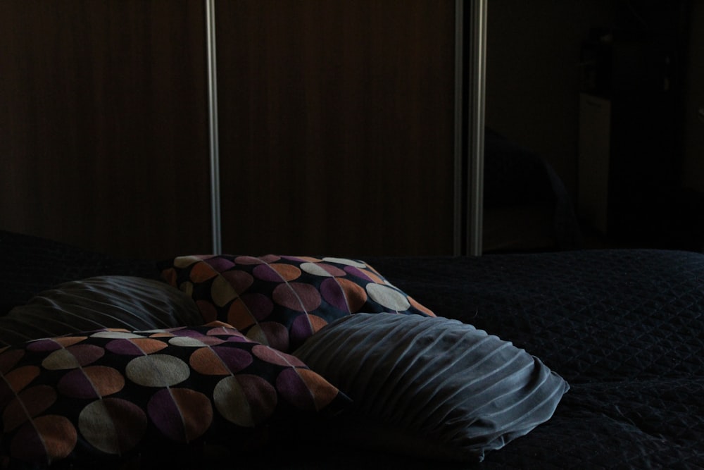 un lit avec une couette noire et deux oreillers