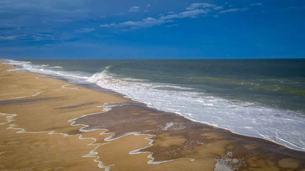 a sandy beach with waves coming in to shore