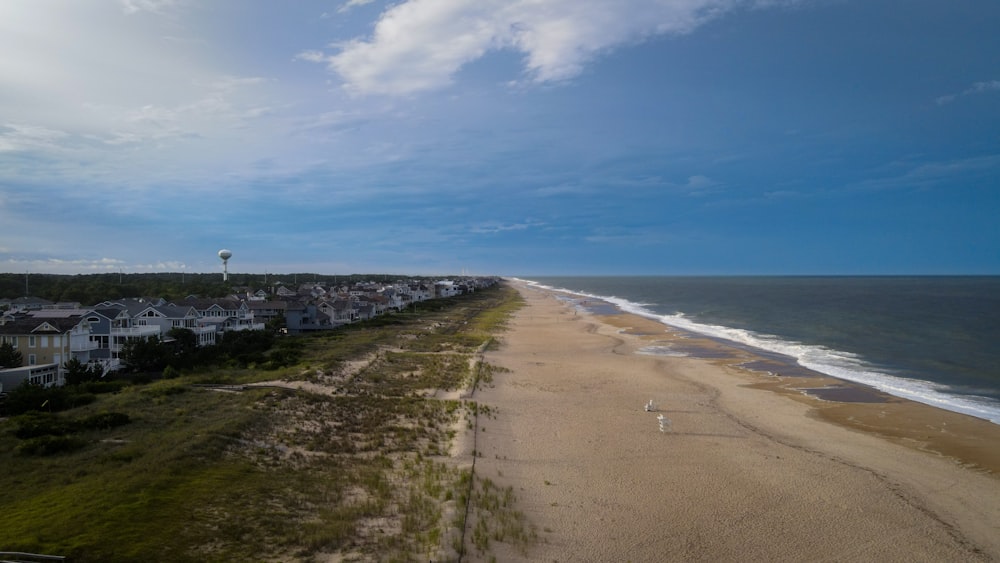 una vista aerea di una spiaggia con case e una mongolfiera in lontananza