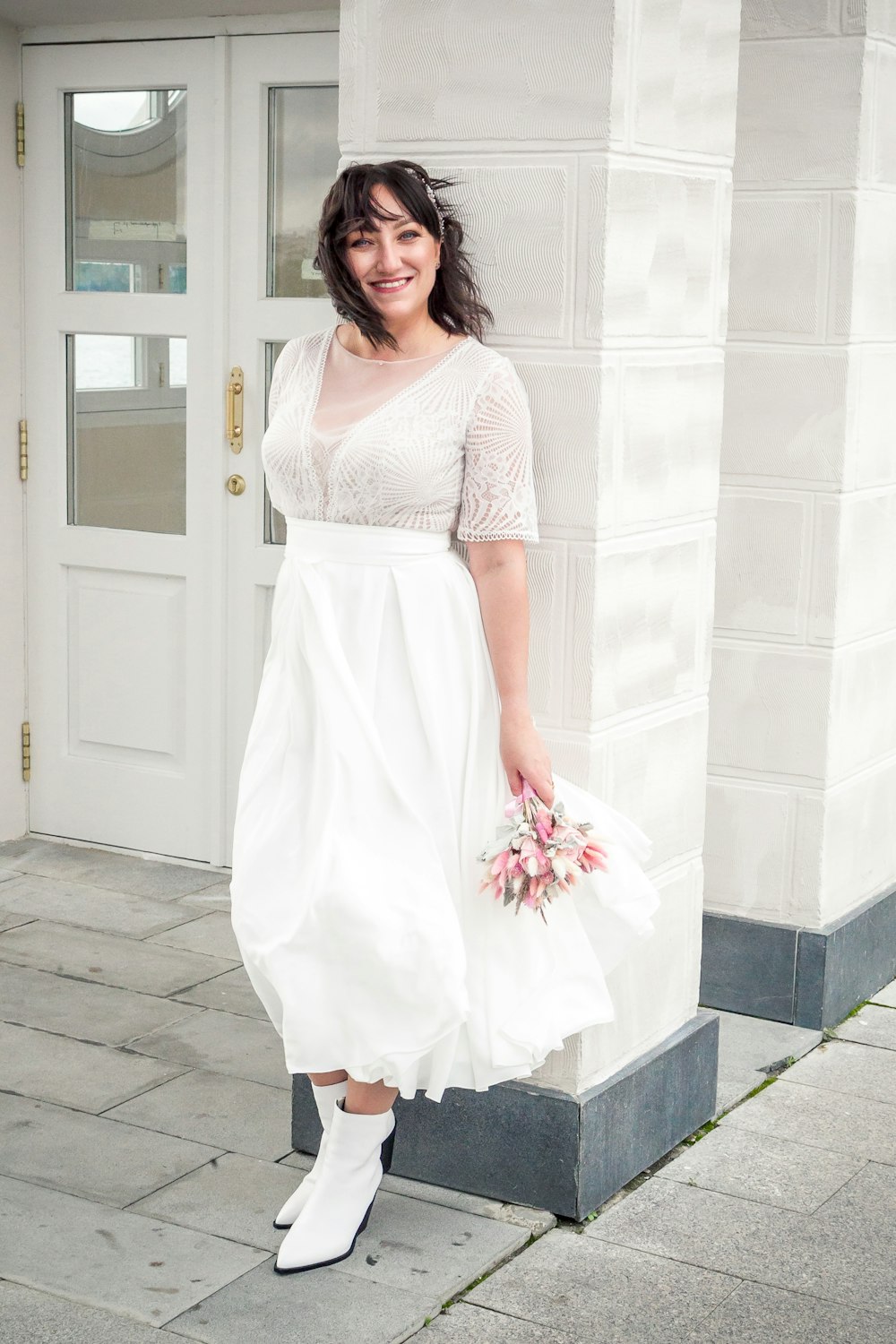 a woman in a white dress holding a bouquet of flowers