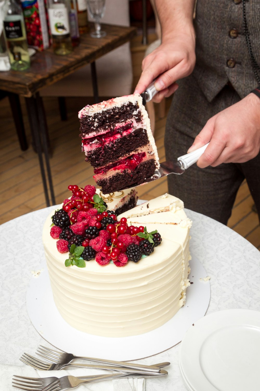 Eine Person, die ein Stück Kuchen mit Messer und Gabel schneidet