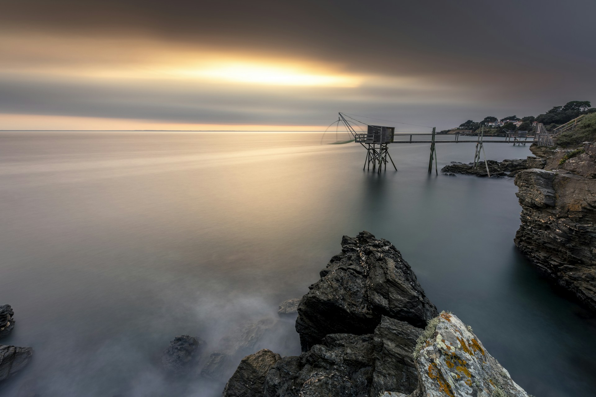 a long exposure photo of a pier on a cloudy day