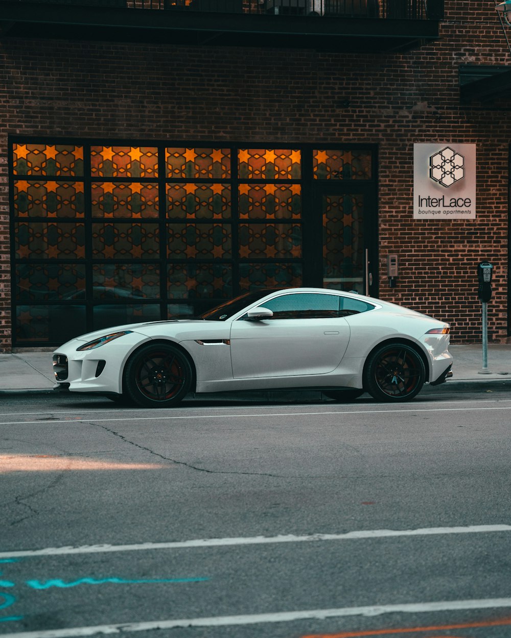 a white sports car parked in front of a building