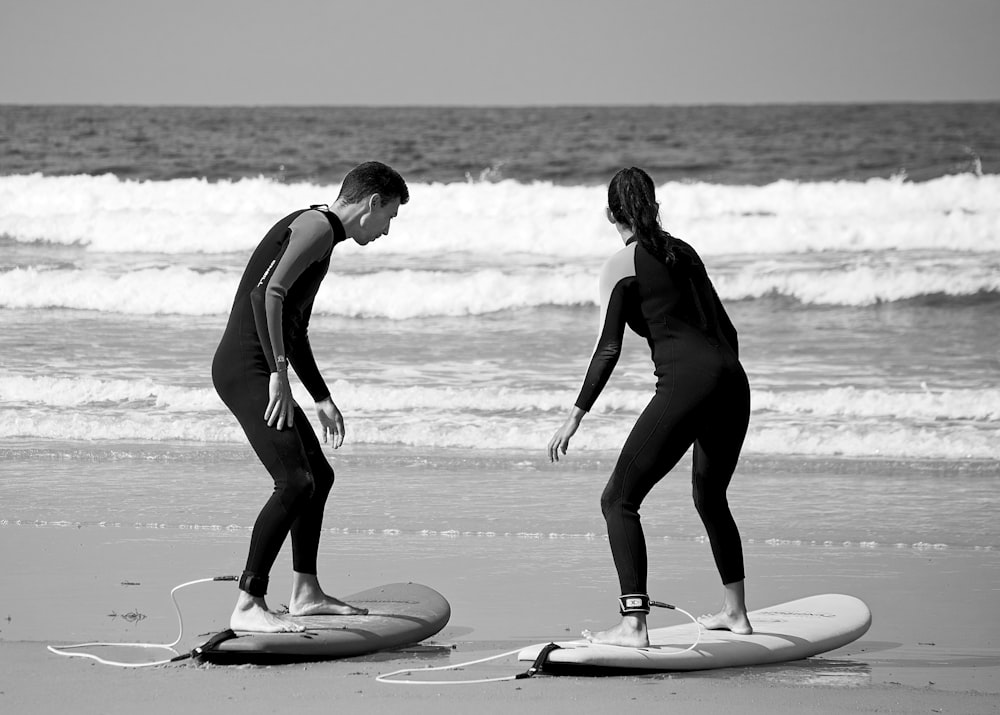 a couple of people that are standing on surfboards