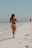 a woman in a bikini running on the beach