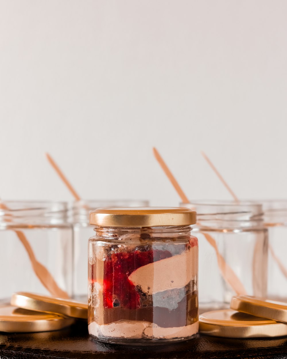 a jar filled with strawberries sitting on top of a table