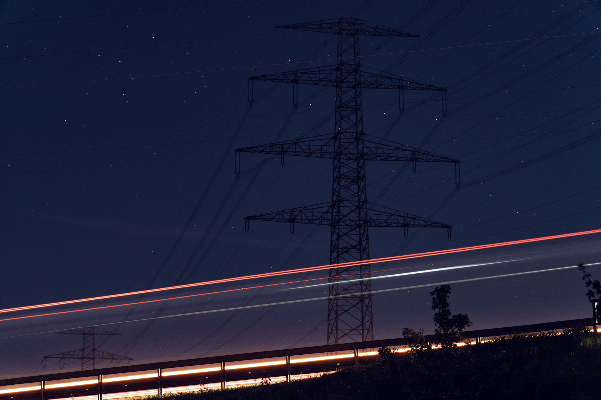 A high-voltage transmission line photographed at night with a long exposure