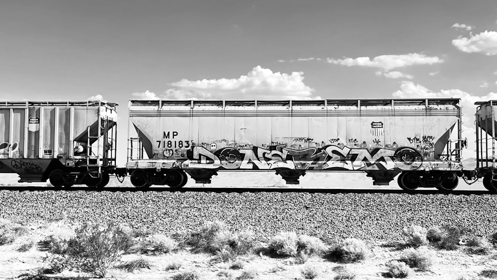 Una foto in bianco e nero di un treno con graffiti su di esso