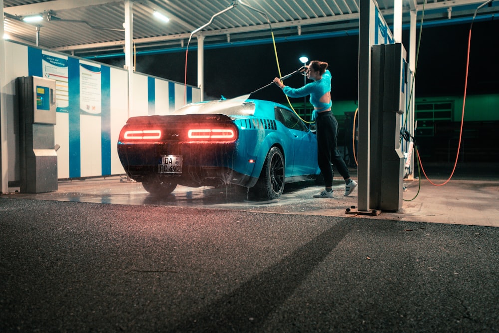 Un homme lave une voiture dans un garage