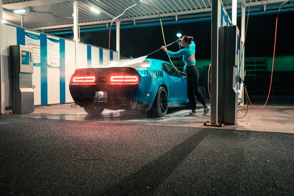 a man washing a car in a garage