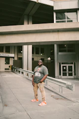 Confident plus size man wearing a casual oversized t-shirt and orange sneakers on the city street.
