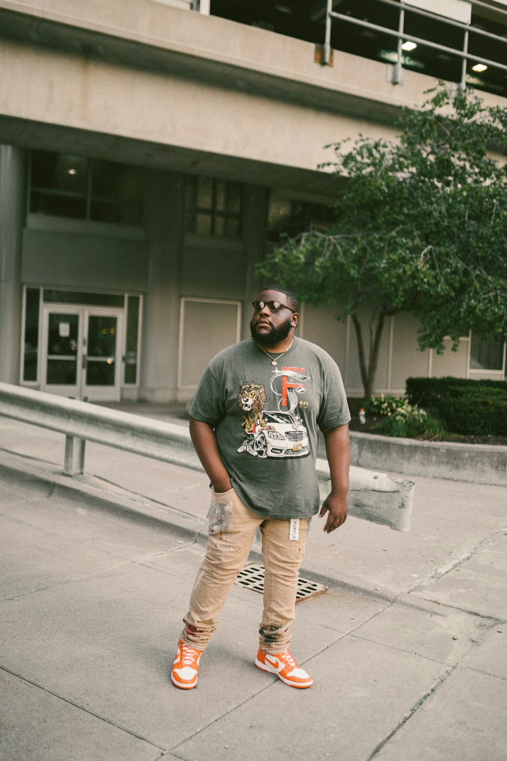 a man standing on a sidewalk in front of a building